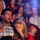 Un hombre y una mujer en el cine y la mujer está buscando fuera de la pantalla