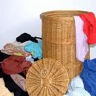 Una cesta llena de ropa a su alrededor