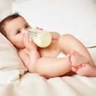 Un pequeño bebé bebe de una botella