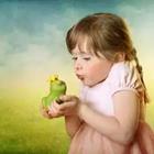 Una niña sostiene una rana verde
