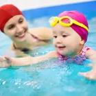 Un adulto y un niño en una piscina con baño-casquillos rojos sobre.