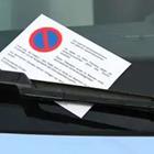 Una nota blanca con un símbolo en él en el parabrisas de un coche